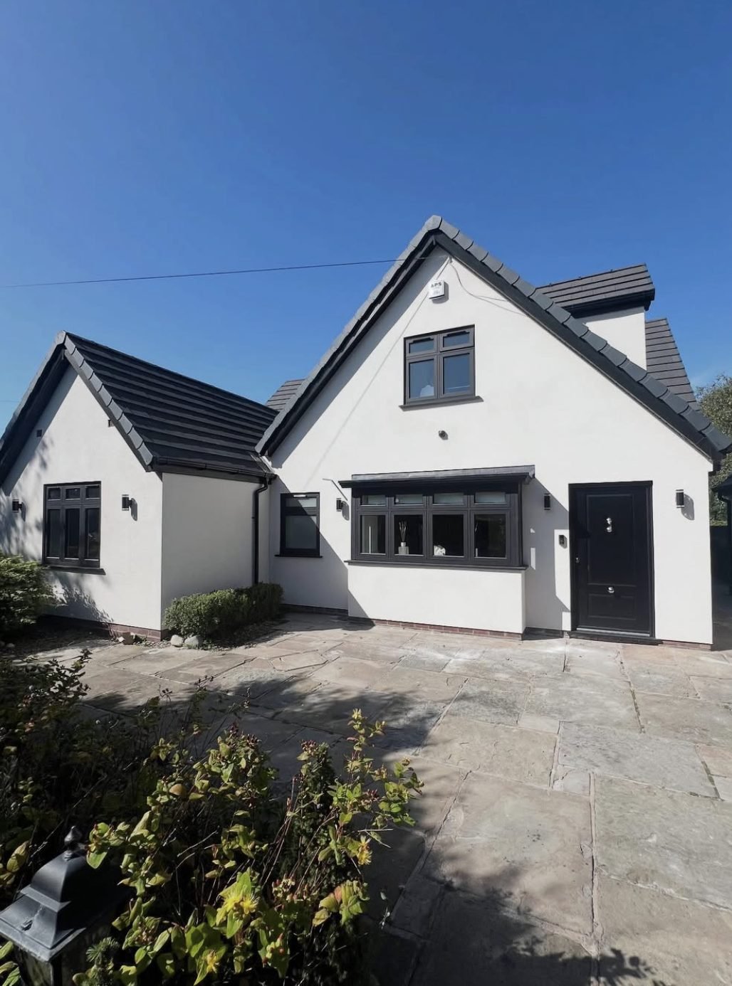 Dormer bungalow in white render beneath a dark tiled roof