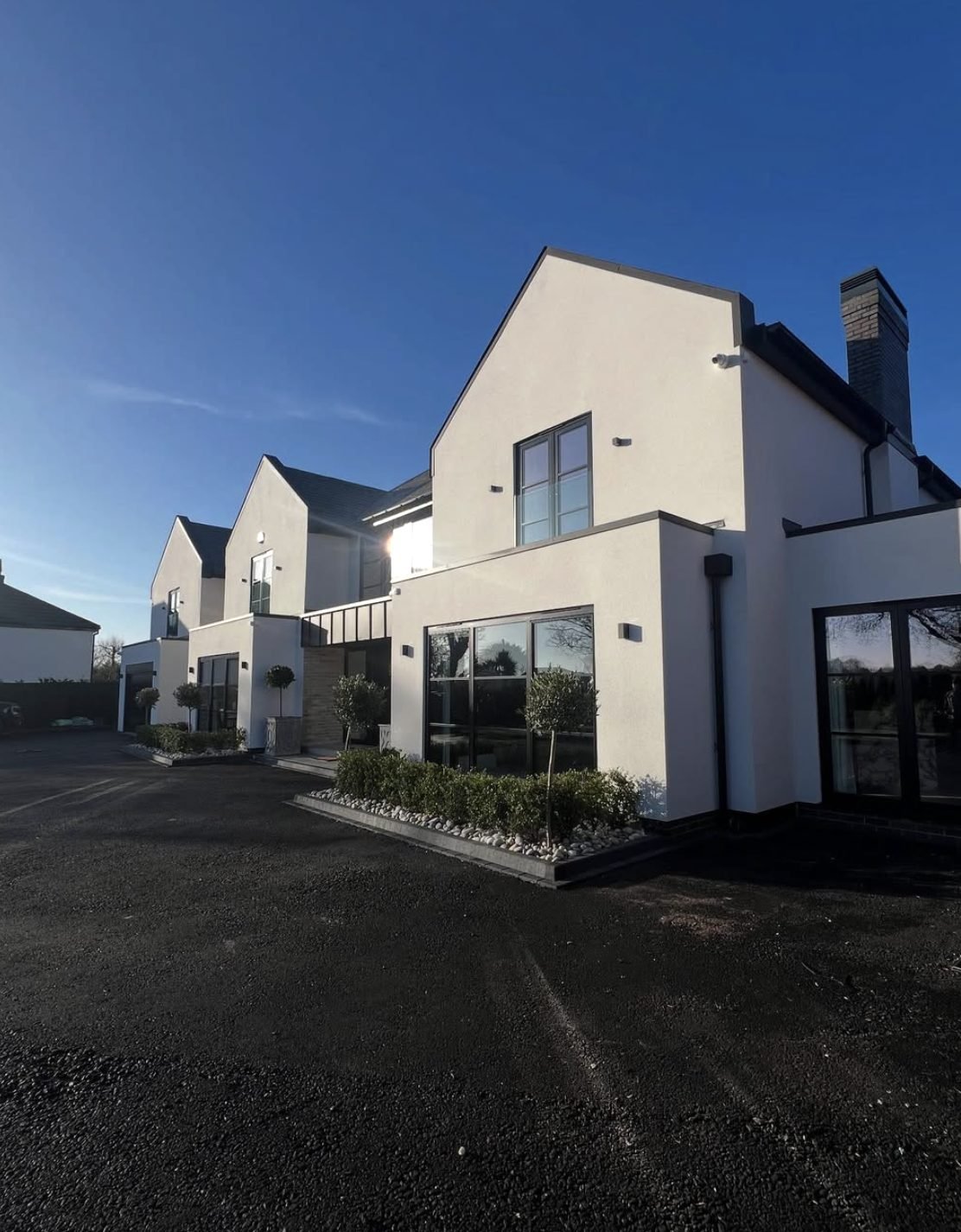 Pair of modern houses in smooth white render with dark grey window frames
